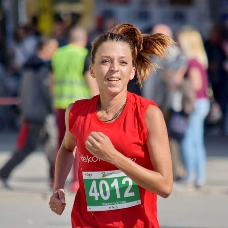 Determined girl running a marathon with focused determination.